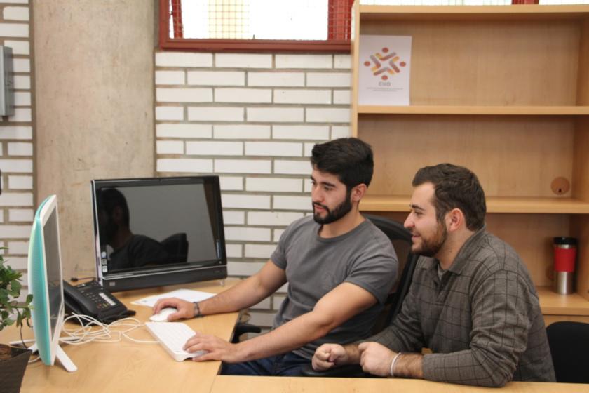 Personas sentadas frente a una computadora 