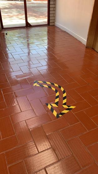 Señalamiento en el piso que indica un vuelta hacia la derecha, entrando por la porta