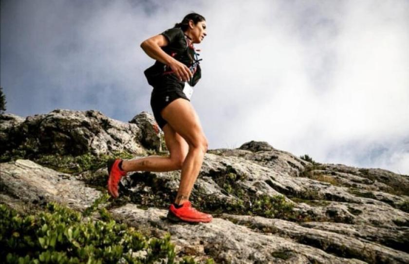 Mujer corriendo por una montaña.