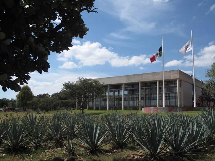 Estructura arquitectónica y, en frente, dos banderas.