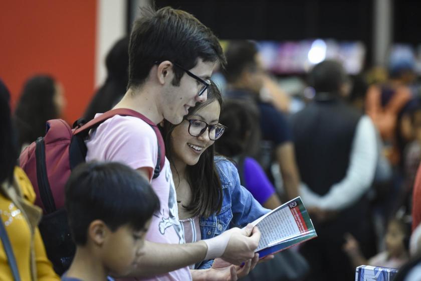 Dos personas leyendo un panfleto.