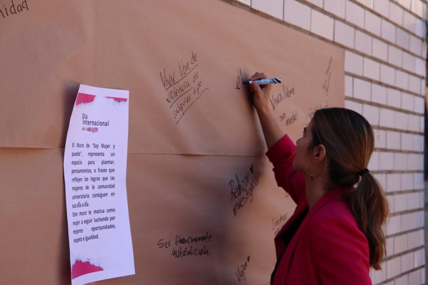 Persona escribiendo en el muro "Porque soy mujer y puedo...".