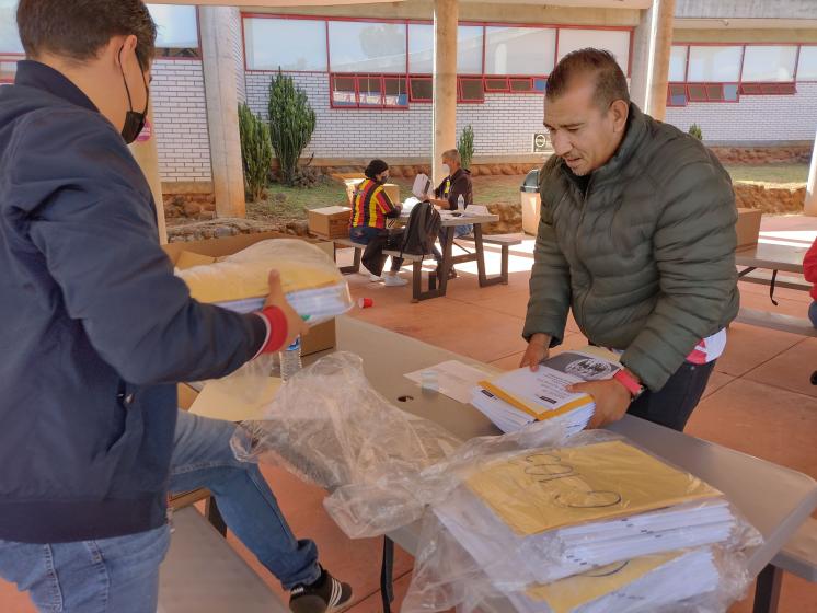 Autoridades manejando paquetes de examen de admisión.