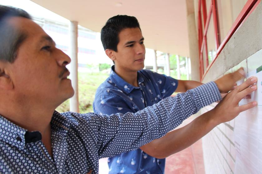 Personas pegando la convocatoria para elegir al próximo Consejo General Universitario.