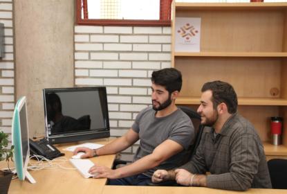 Personas sentadas frente a una computadora 
