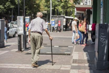 Un señor de terca edad caminando en las calles