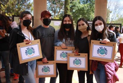 Alumnos sosteniendo folders en los que se lee "Feria del Empleo".