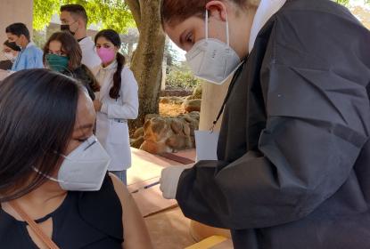 Integrante del programa de vacunación de refuerzo a personal docente aplicando una vacuna.