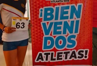 Estudiante de negocios, Yadira Franco, posando al lado del cartel "5to Circuito Nacional de Caminata Coatzacoalcos".